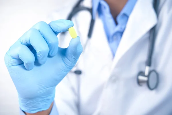 Läkare handen i latexhandskar håller medicinska piller närbild — Stockfoto