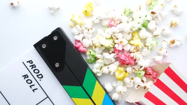 Film clapper bord en popcorn op witte achtergrond — Stockvideo