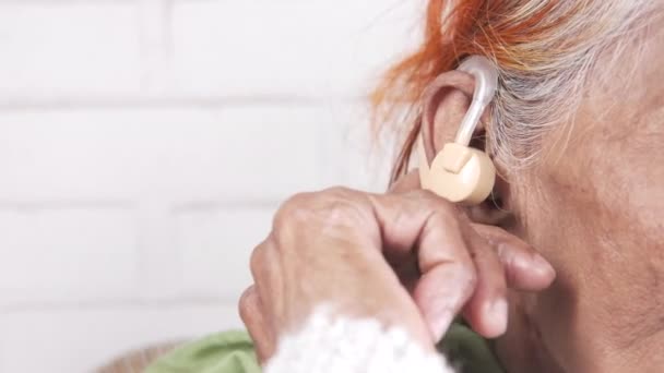 Hoortoestel concept, een oudere vrouw met gehoorproblemen. — Stockvideo