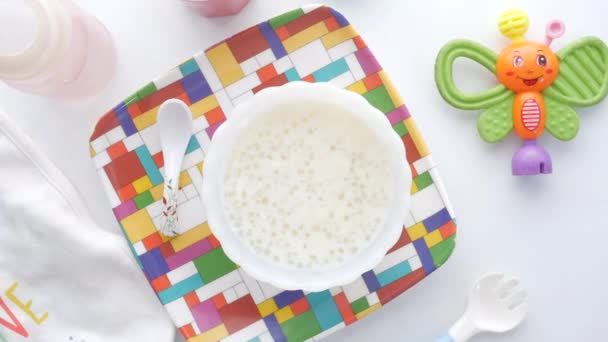 Vista superior de la comida para bebés en un tazón sobre fondo blanco — Vídeos de Stock