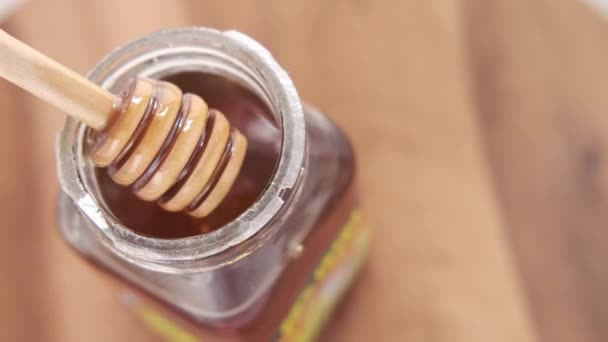 Φρέσκο μέλι με κουτάλι στο τραπέζι — Αρχείο Βίντεο