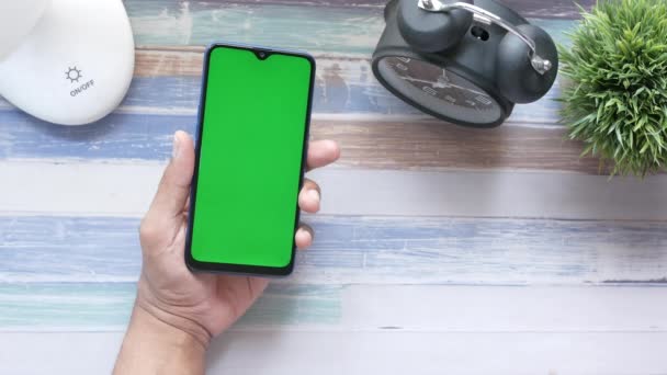 Överst på sidan av man hand hålla smart telefon på bordet — Stockvideo
