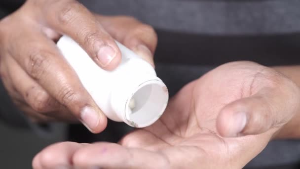 Mans main avec des médicaments renversés dans le récipient de la pilule — Video