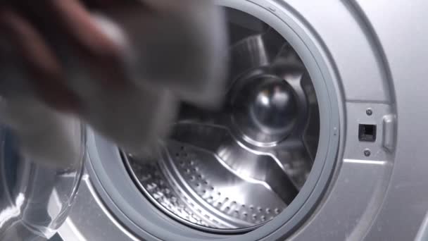 Bir çamaşır makinesine havlu ve bez koymak. — Stok video