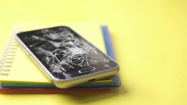 Primo piano dello smartphone rotto su sfondo giallo — Video Stock