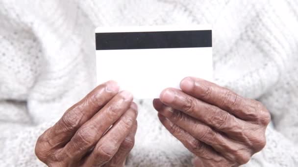 Крупним планом старша рука тримає кредитну картку — стокове відео