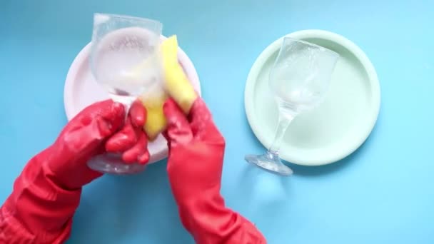 Hand in rubber gloves cleaning plate and glass — Stock Video