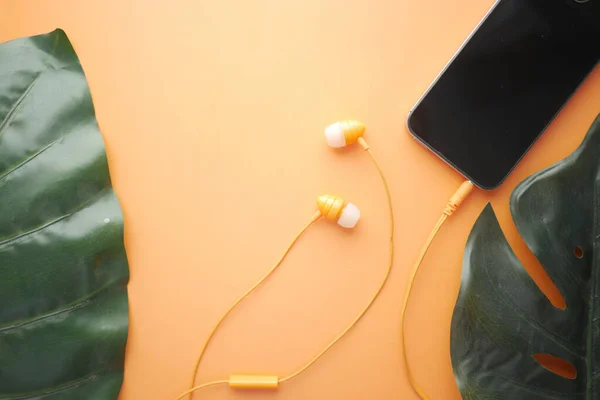 Téléphone intelligent avec écran vide, écouteur sur fond orange — Photo