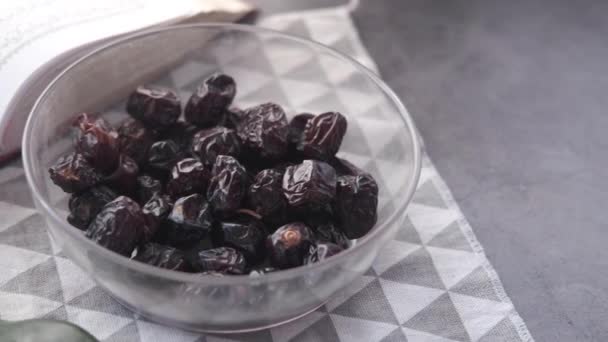 Närbild av färsk frukt i en skål och järnek bok av Koranen på bordet — Stockvideo