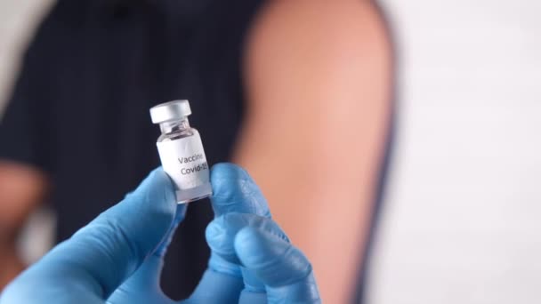 Mão em luvas de látex segurando vacina ampola de vidro, com espaço de cópia — Vídeo de Stock