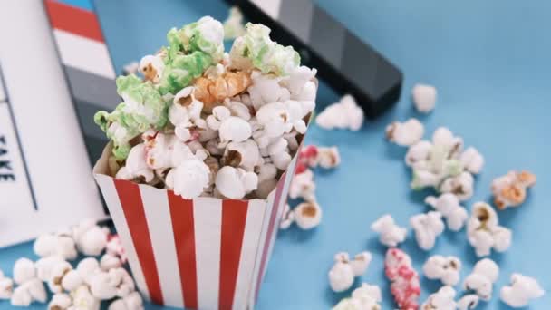 Film tapsoló tábla és popcorn fehér alapon — Stock videók