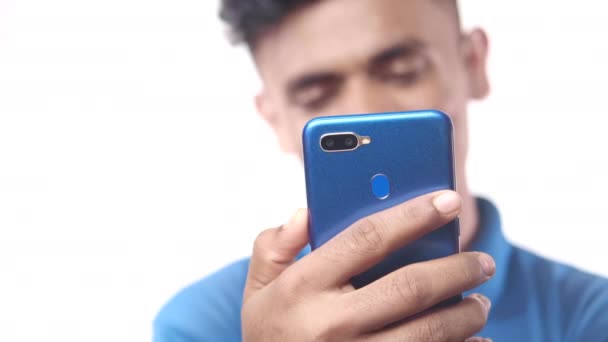 Улыбающийся молодой человек в очках использует свой телефон, чтобы сделать видеозвонок — стоковое видео