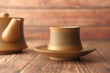 Çay fincanını ahşap masaya kapat. 