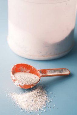 Siyah arka planda plastik kaşıkla yıkama tozu..