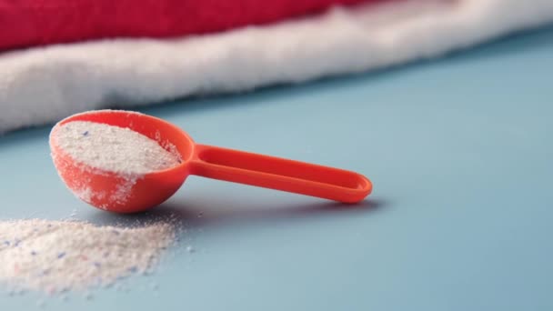 Washing powder in plastic spoon on black background top view. — Stock Video