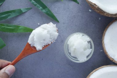 Hindistan cevizi yağlı kaşık ve siyah arka planda fındık 