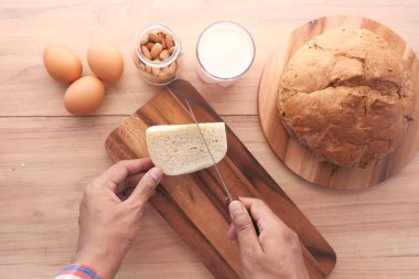 Doğranmış tahtada peynir kesen adamın düz kompozisyonu 