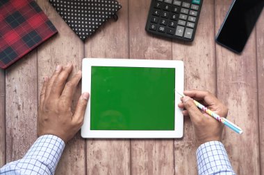 Dijital tableti ofis masasında dava eden genç adamın düz kompozisyonu 