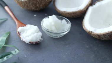 Hindistan cevizi yağlı kaşık ve siyah arka planda fındık 