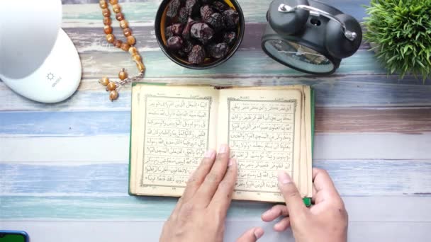 Μουσουλμάνος άνθρωπος χέρι γυρίζοντας σελίδες του Holly βιβλίο του Quran κορυφή άποψη — Αρχείο Βίντεο