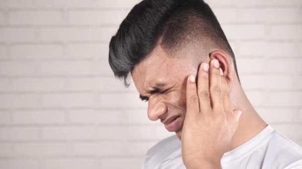 Jovem tendo dor de ouvido tocando sua orelha dolorosa , — Vídeo de Stock