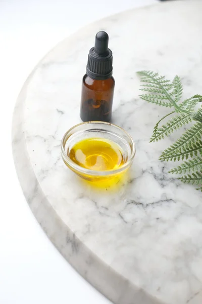 Aceites esenciales de eucalipto en una botella de vidrio con hoja verde sobre azulejos — Foto de Stock