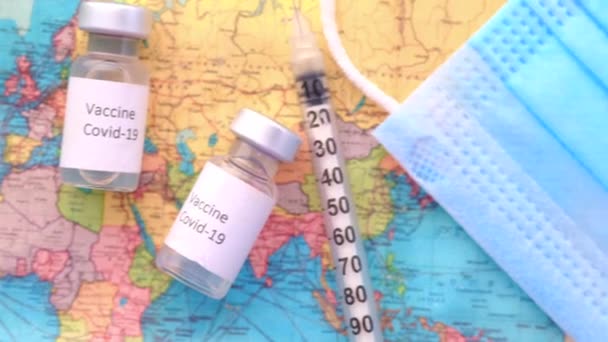 Großaufnahme von Coronavirus-Impfstoff und Spritze auf einer Reisekarte — Stockvideo