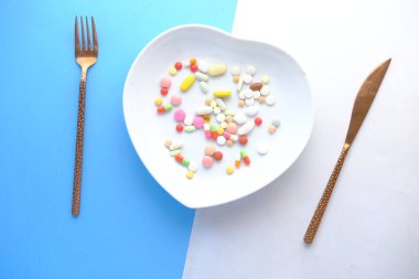 Tabaktaki pek çok renkli hap ve kapsülün üst görüntüsü 