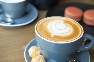 Kafenin tepesinde çiçek desenli geç kalmış bir fincan kahve. 