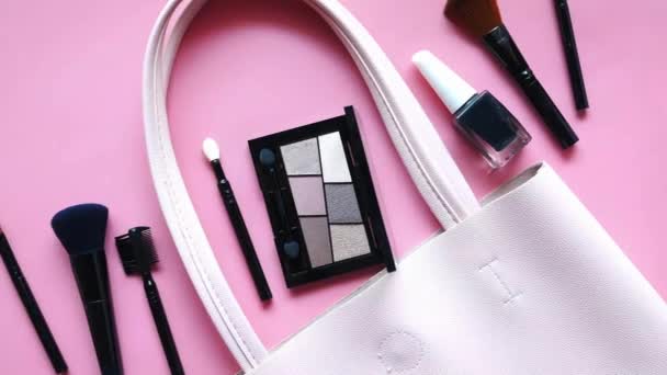 Vista superior de la cosmética decorativa de color negro sobre fondo rosa — Vídeos de Stock