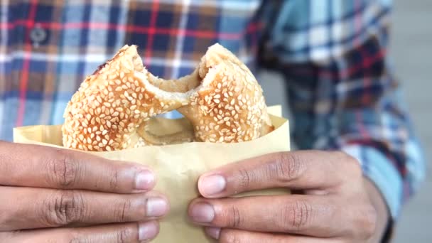 Mano sosteniendo pan de bagel fresco en una bolsa de papel — Vídeos de Stock