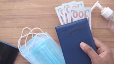 Koruyucu maske, Amerikan doları ve mavi renkli pasaport. 