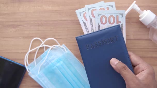 Προστατευτική μάσκα, δολάριο και μπλε χρώμα διαβατήριο στο τραπέζι — Αρχείο Βίντεο