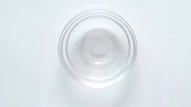 Primer plano de las píldoras y cápsulas médicas en un recipiente pequeño sobre fondo blanco — Vídeo de stock