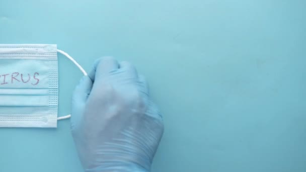 Χέρι σε ιατρικά σφαιρίδια κρατώντας χειρουργική μάσκα προσώπου, — Αρχείο Βίντεο