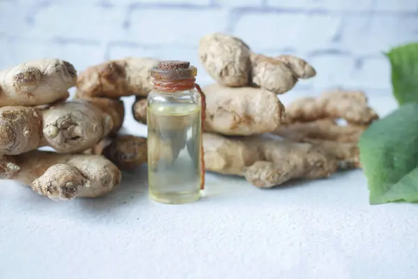 Close up de Gingers e óleos em uma pequena garrafa de vidro na mesa — Fotografia de Stock