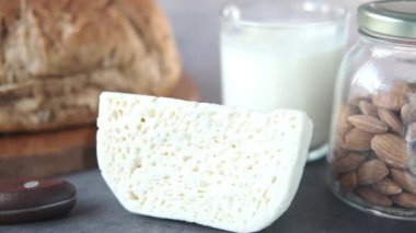 Peyniri, sütü, kahverengi ekmeği ve badem fıstığını masaya yakın..