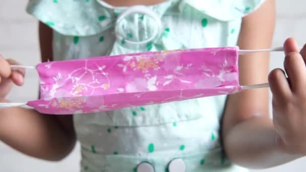 Bambino mano che tiene il colore rosa fatto in casa maschera — Video Stock