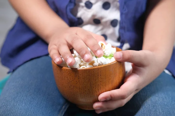 Child girl hand holding a bowl of colorful popcorn — Stock Photo, Image
