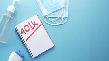 Mavi arka planda 401k sözcüğü ve yüz maskesi olan not defteri,