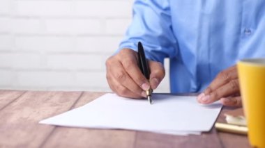 Adam dolmakalem ya da kağıt üzerinde imza verdi. .