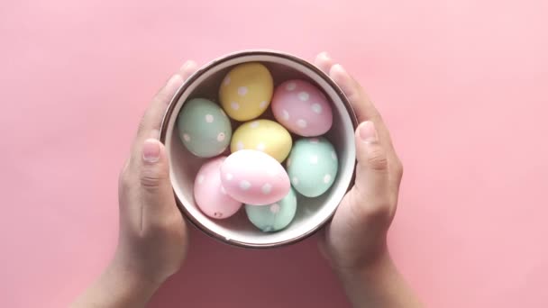 Niño mano sosteniendo un tazón de huevos de Pascua en rosa — Vídeo de stock