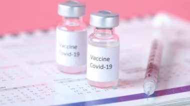 Coronavirus aşısı, şırınga ve takvim masada. 