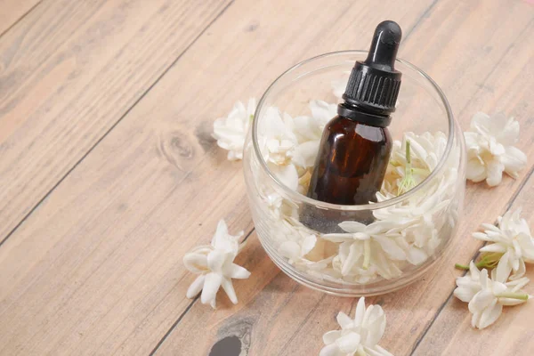 Aceites esenciales de eucalipto en una botella de vidrio y flor sobre fondo de madera — Foto de Stock