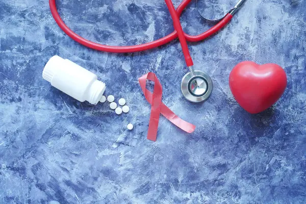 Red ribbon HIV, and stethoscope on black background. — Stock Photo, Image