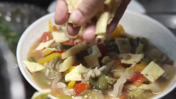 Poner rebanada de huevos en sopa de verduras en un tazón — Vídeo de stock