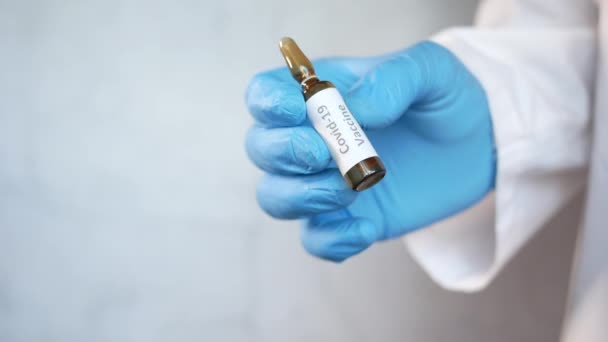 Latexové rukavice držící skleněnou ampulovou vakcínu, s kopírovacím prostorem — Stock video