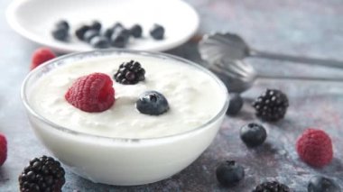Bir kasede mavi böğürtlenli taze yoğurt. 