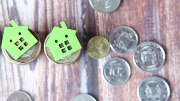 桌子上有一堆硬币的绿色木制房子 — 图库视频影像