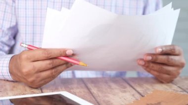 Genç adam kağıt üzerinde finansal verileri analiz ediyor. 